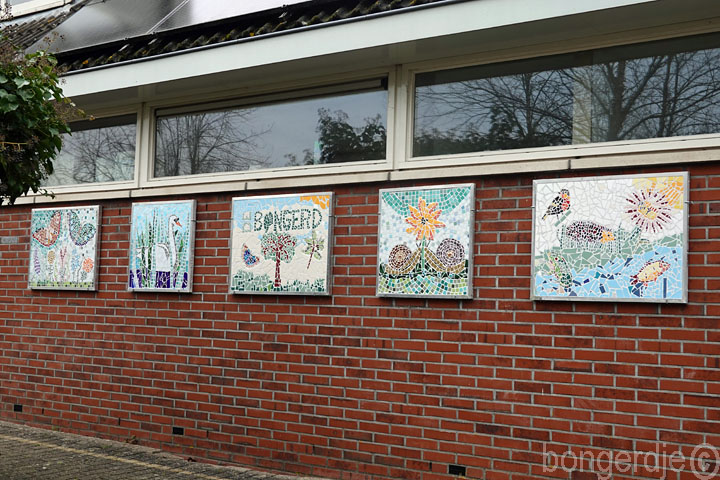 mozaïektableaus aan de muur van clubhuis De bongerd